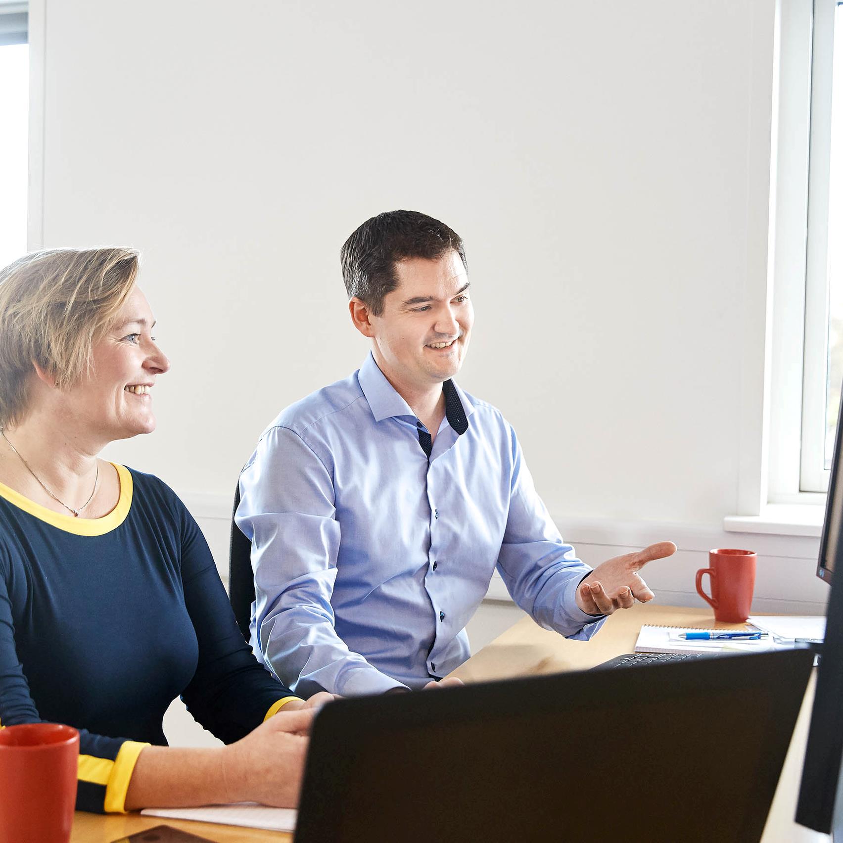 En glad Acies medarbejder som snakker i telefon